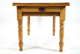 A pine table with one frieze drawer on turned legs,