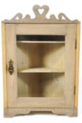 A pine hanging corner cupboard, with pierced crest above a glazed door, 69cm high, 45.