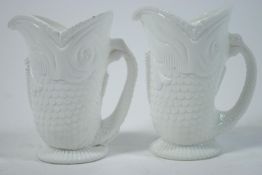 A pair of Heppel opaque glass jugs, modelled in the form of fish in white,