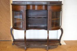 An Edwardian mahogany display cabinet with a serpentine front,