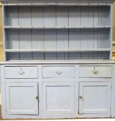 A painted pine dresser, with three drawers and two doors, a plate rack fitted with cup hooks,