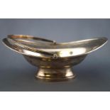 A silver small scale swing handled cake basket, of oval form, with applied reeded edge,