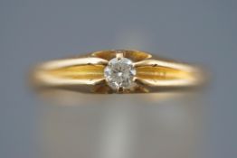 A yellow metal single stone ring. Set with a round brilliant cut diamond of approximately 0.15cts.