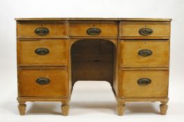 A 19th century pine kneehole desk with inverted breakfront,