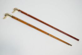 Two walking canes, each with brass duck head knops,