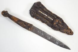 A Congolese knife, in wood and iron, the handle with a male mask finial,