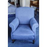 A blue upholstered armchair on turned legs