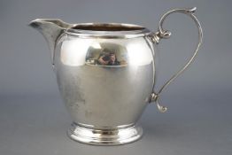 A silver three piece tea service of plain rounded form, with reeded tops and bases,