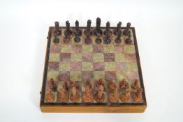 An Indian carved soapstone chess set with figures in the style of the Qutub Minar in Delhi,