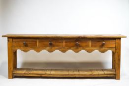A pine dresser base, with four drawers above a shaaped apron with an open under tier,