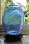 Two soda glass vases, one in blue on Chinese hardwood stand,