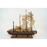 A wooden model of a four masted battleship, set with three decks of cannons,