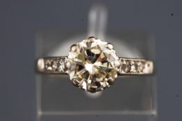 A white metal diamond ring set with a single round brilliant cut diamond