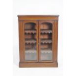 A Victorian mahogany standing bookcase with two arched glazed doors on plinth base,