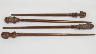 A group of four carved mahogany walking sticks,