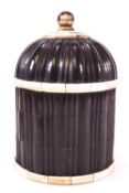 An ebony tea caddy, of ribbed form with hemispherical domed cover,