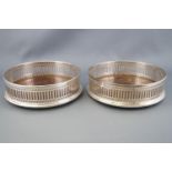 A pair of silver wine coasters, of straight sided form with pierced decoration,