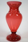 A large cranberry tinted glass vase, of baluster form,