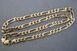 A yellow metal heavy linked Figaro chain, trigger clasp, 570mm.