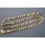 A yellow metal heavy linked Figaro chain, trigger clasp, 570mm.