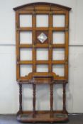 A 19th century oak hall stand with central mirror panel surrounded by eight brass hooks,