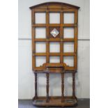 A 19th century oak hall stand with central mirror panel surrounded by eight brass hooks,