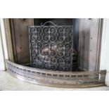 A wrought iron fire guard, together with a George III steel fender,