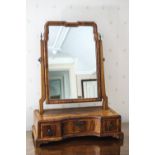 A 17th century style walnut swing frame mirror, the shaped base with three drawers,