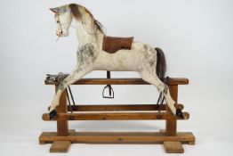 An early 20th century carved wood and painted rocking horse, with horsehair mane and tail,