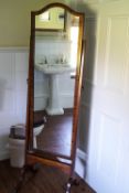 A 19th century mahogany cheval mirror with brass paw terminals and casters,