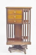 An Edwardian mahogany revolving bookcase, with marquetry top, the sides with three unusual drawers,