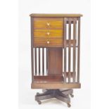 An Edwardian mahogany revolving bookcase, with marquetry top, the sides with three unusual drawers,
