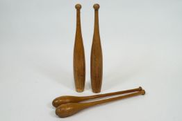 Two pairs of Indian turned wood clubs,
