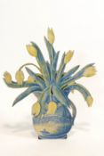 A cut out dummy board in the form of tulips in a Delft jug, painted in monochrome blue,