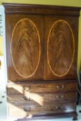 A George III mahogany linen press with satinwood stringing and three graduated drawers,