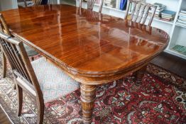 A Victorian mahogany dining table with three loose leaves, on turned and reeded legs,