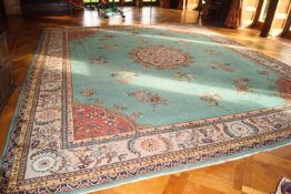 A large 20th century Chinese style carpet with central medallion on a green ground within one wide