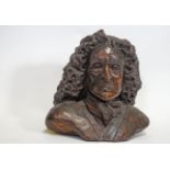A clay bust of an 18th century gentleman in a large curled wig,