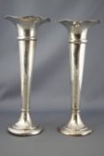 A pair of loaded silver trumpet form spill vases, with petal form rims, Birmingham 1905,