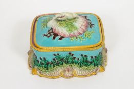 A majolica butter dish and cover, modelled with a shell and seaweed knop,