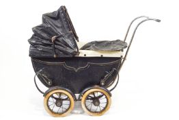 An early/mid 20th century child's dolls pram with folding over a deep body on a suspended base