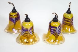 Four Favrille style light shades, of tulip form in iridescent yellow with trailed purple overlay,