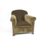 A small Howard & Sons style armchair with domed sloping back with elongated seat and scroll arms,