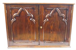 A pine side cabinet, the two panelled doors with Gothic style applied arches,