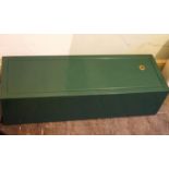 A modern green metal gun cabinet with keys,