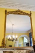 A 19th century gilt framed over-mantel mirror with scrolls to the architectural pediment,