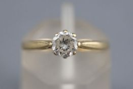 A yellow metal single stone ring. Set with a round brilliant cut diamond of approximately 0.46cts.