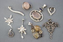 A collection of ten white metal pendants of variable designs.
