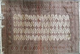 A Bokhara rug, with repeating lozenges on a beige field within multiple boarders,