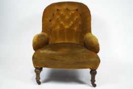 A Victorian button back armchair with small arms and a stuff over seat,